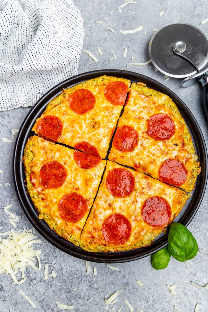 Bovenaanzicht van pepperoni pizza op een bloemkool korst pizza pan.