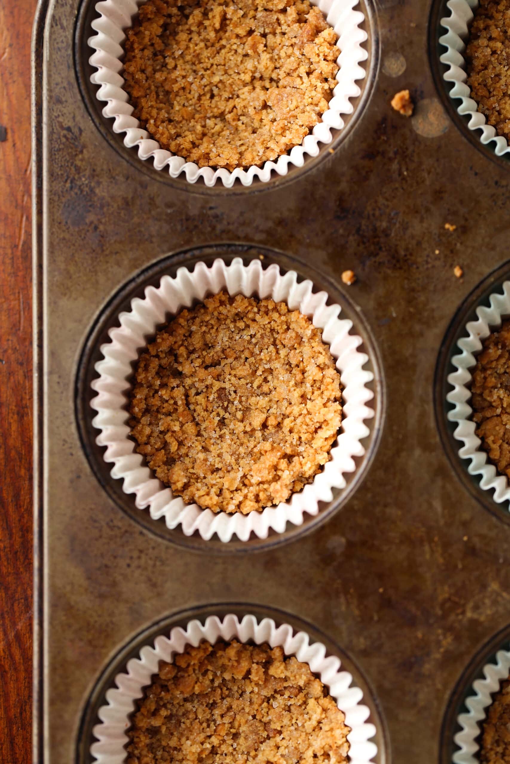 Graham cracker korst in een cupcake voering gebakken in een muffinvorm