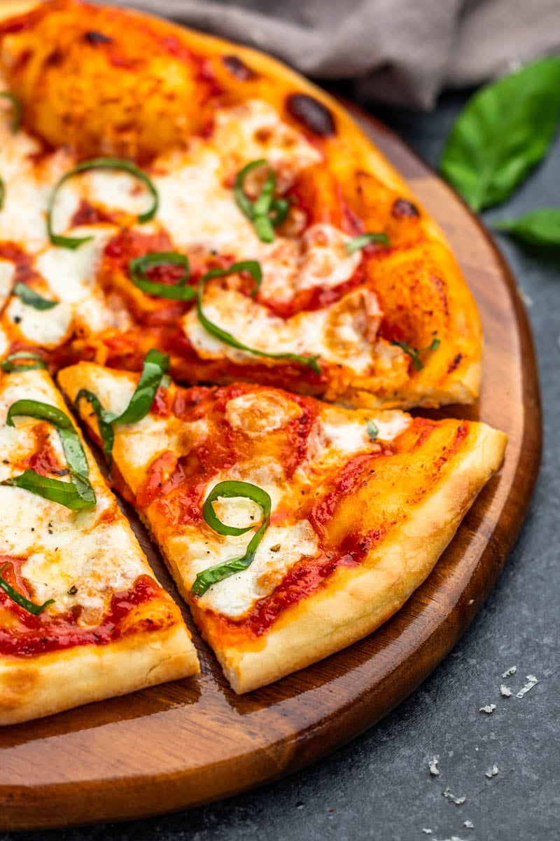 Margherita-pizza op een houten pizzabord.